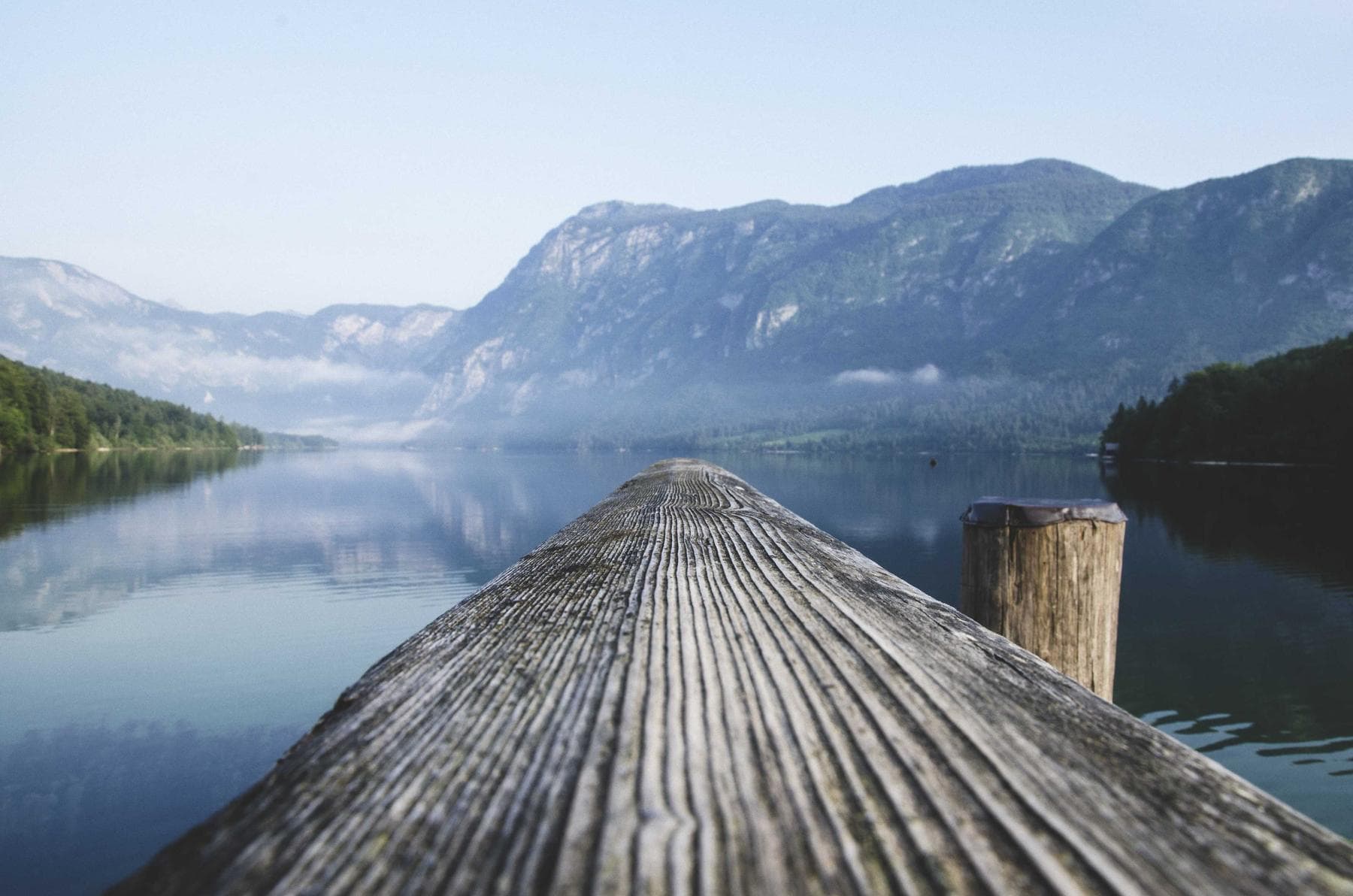 Holzsteg, der in einen ruhigen See führt
