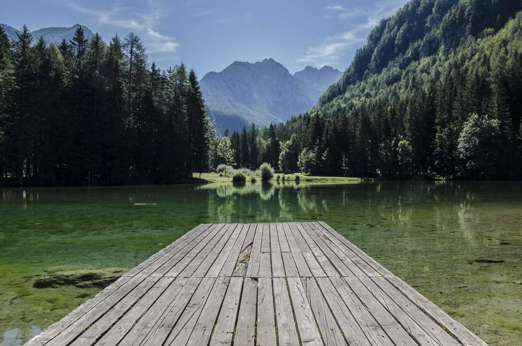 Holzsteg an einem klaren Bergsee